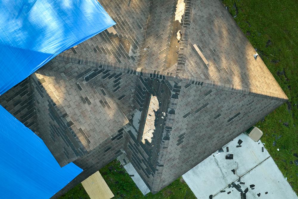 Address Geist Storm Damage with help from Beard Roofing & Exteriors image shows roof with damage to shingles