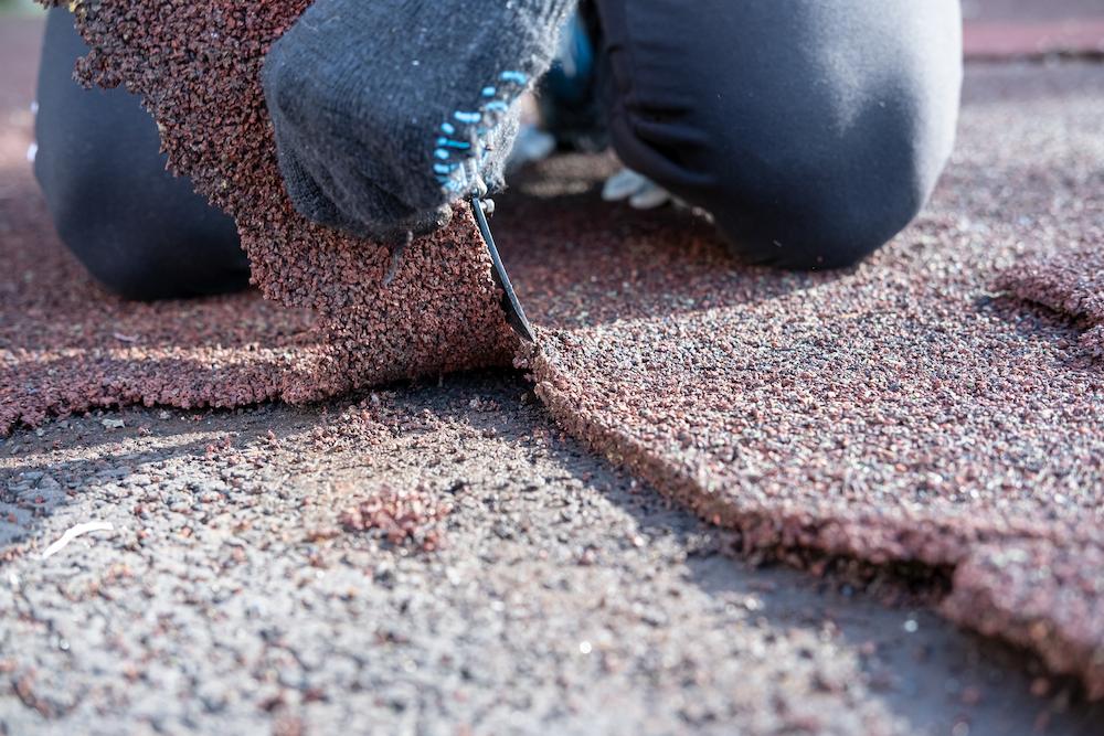 Contact Beard Roofing & Exteriors for Zionsville Roof Repair work image shows hand grasping roofing material