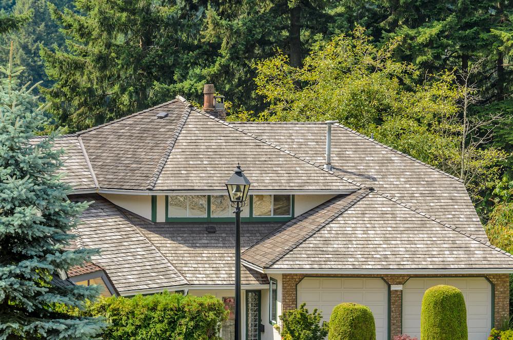 Tackle Zionsville Roof Replacement with expertise from Beard Roofing & Exteriors image shows roof of suburban home next to trees